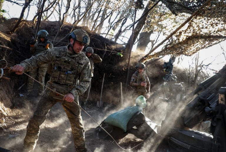 Ukrainian servicemen fire a howitzer towards Russian troops in Donetsk region